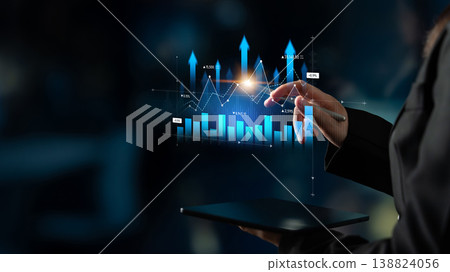 Professional person analyzing financial data on digital tablet with glowing graphs and charts in a modern office environment at night Scalp 138824056