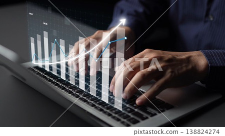 Hands typing on a laptop with graphic overlay showing financial graphs and trends in a modern business environment for data analysis and reporting Copula 138824274