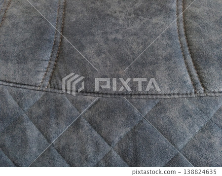 Close-up view of a gray quilted fabric showing detailed stitching and texture from a textile design Close-up view of a gray quilted fabric showing detailed stitching and texture from a textile design 138824635