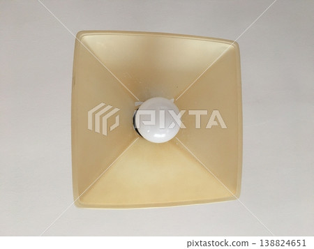 View from below of a ceiling light fixture with a square shape shining bright in a room during daytime View from below of a ceiling light fixture with a square shape shining bright in a room during daytime 138824651