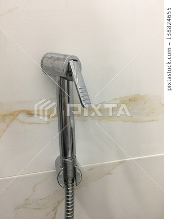 Modern faucet installed on a bathroom wall in a residential space Modern faucet installed on a bathroom wall in a residential space 138824655