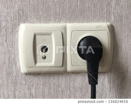 Wall socket with TV connection and power plug in a home setting during the daytime Wall socket with TV connection and power plug in a home setting during the daytime 138824658