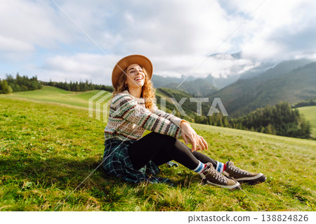 Cheerful happy woman smiles, laughs, emotional in nature, against backdrop of mountain landscapes. Cheerful happy woman smiles, laughs, emotional in nature, against backdrop of mountain landscapes. 138824826