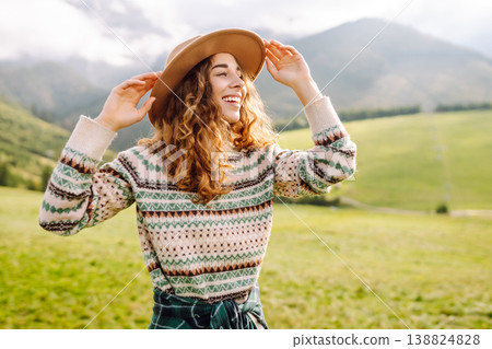 Cheerful happy woman smiles, laughs, emotional in nature, against backdrop of mountain landscapes. 138824828