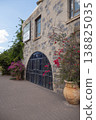 Historic Stone Building Entrance with Arched Gate and Bougainvillea 138825035