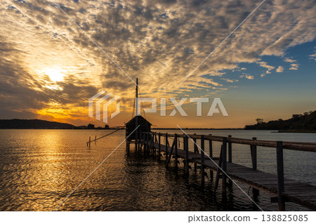 Evening view of Lake Togo with a pier and a hut. Evening view of Lake Togo with a pier and a hut. 138825085