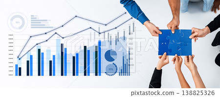 Collaborative Business Team Analyzing Financial Data with Charts and Graphs on Table, Close-up of Hands Holding Puzzle Piece and Documents, Modern Office Setting Scalp 138825326
