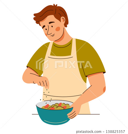 Contented man in an apron add seasonings onto a fresh salad. Cooking scene featuring healthy food Contented man in an apron add seasonings onto a fresh salad. Cooking scene featuring healthy food 138825357