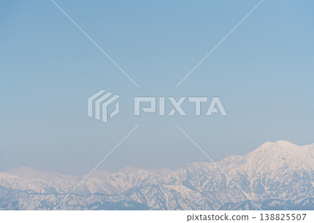 The Tateyama mountain range shines brightly with lingering snow. 138825507