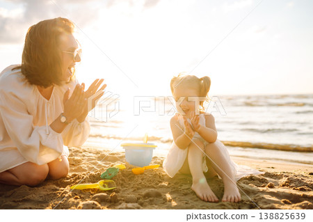 Mother and daughter enjoying time at the beach. Plays toys. Family vacation. Mother and daughter enjoying time at the beach. Plays toys. Family vacation. 138825639
