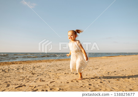 Young girl joyfully plays on the sandy beach during sunset, enjoying a carefree moment by the ocean Young girl joyfully plays on the sandy beach during sunset, enjoying a carefree moment by the ocean 138825677