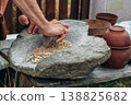 Human hand rotating an ancient stone grinding machine for smashing grains. Handmade manual equipment grind mill 138825682