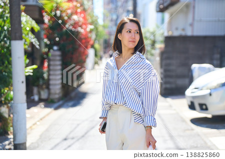 一位日本女子一邊看著手機一邊購物,臉上帶著微笑。這是她在假日裡漫步城市時的照片。 一位日本女子一邊看著手機一邊購物,臉上帶著微笑。這是她在假日裡漫步城市時的照片。 138825860