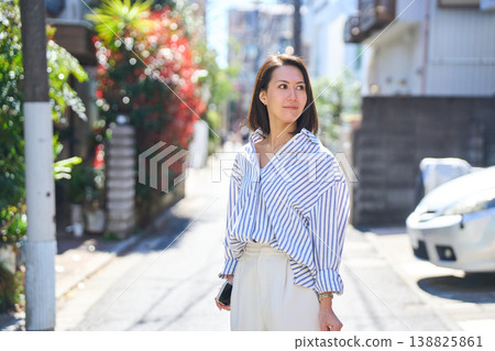 一位日本女子一邊看著手機一邊購物,臉上帶著微笑。這是她在假日裡漫步城市時的照片。 一位日本女子一邊看著手機一邊購物,臉上帶著微笑。這是她在假日裡漫步城市時的照片。 138825861