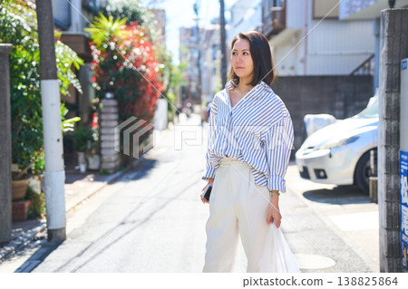 一位日本女子一邊看著手機一邊購物,臉上帶著微笑。這是她在假日裡漫步城市時的照片。 一位日本女子一邊看著手機一邊購物,臉上帶著微笑。這是她在假日裡漫步城市時的照片。 138825864