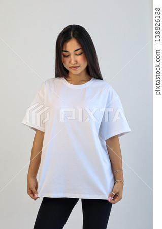 Ecommerce promotional image showcasing confident woman wearing white tshirt in studio setting Ecommerce promotional image showcasing confident woman wearing white tshirt in studio setting 138826188