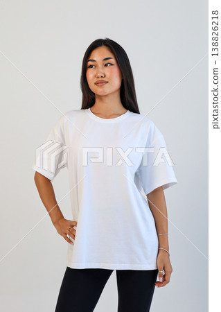 Ecommerce promotional image showcasing confident woman wearing white tshirt in studio setting 138826218
