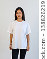 Front view of woman in white shirt. Studio portrait of woman in casual attire with blank background 138826219