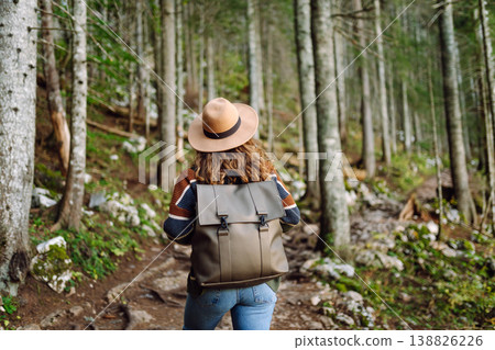 Woman with backpack hiking outdoors in the Forest. Trekking in the Pine Woods. Hiking lifestyle Woman with backpack hiking outdoors in the Forest. Trekking in the Pine Woods. Hiking lifestyle 138826226