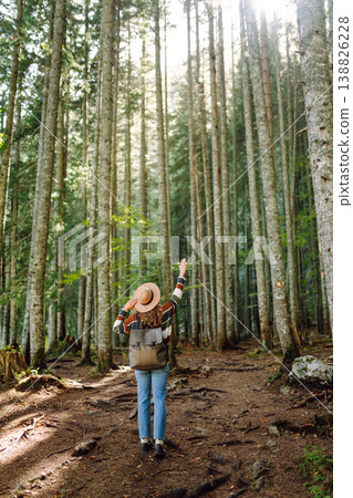 Woman with backpack hiking outdoors in the Forest. Trekking in the Pine Woods. Hiking lifestyle Woman with backpack hiking outdoors in the Forest. Trekking in the Pine Woods. Hiking lifestyle 138826228