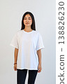 Front view of woman in white shirt. Studio portrait of woman in casual attire with blank background 138826230