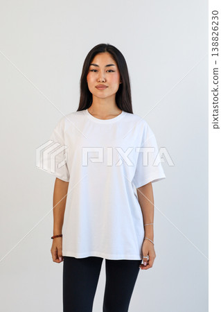 Front view of woman in white shirt. Studio portrait of woman in casual attire with blank background 138826230