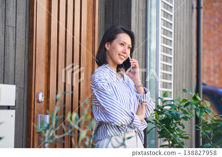 一位日本女性在家門口打電話時的側臉。 138827958