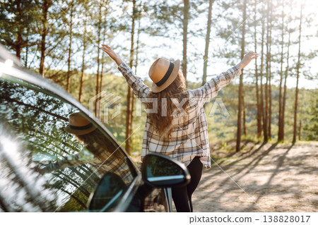 Young woman enjoying and having fun in their vacations outdoors leaning out car window. Summer trip. 138828017