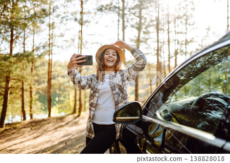 Selfie in nature. Woman tourist standing near car and enjoy nature. Active lifestyle, travel. Selfie in nature. Woman tourist standing near car and enjoy nature. Active lifestyle, travel. 138828018
