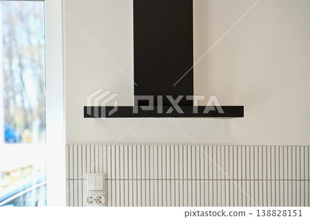 Modern black kitchen hood on wall in bright interior Modern black kitchen hood on wall in bright interior 138828151