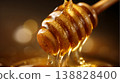 A macro photograph capturing the mouthwatering sight of rich, golden honey dripping from a wooden honey dipper. 138828400