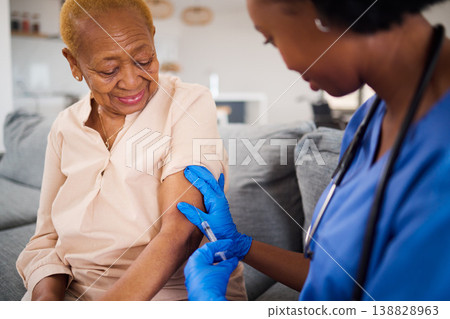 Healthcare, black woman and doctor for a home vaccine, virus safety and security from covid. Smile, medicine and and African nurse with a senior patient and giving a vaccination during a consultation 138828963