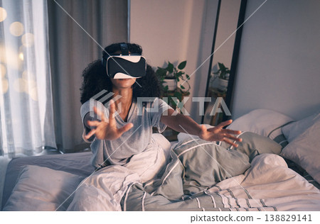 Woman, bed and vr game in night, home and online in metaverse, matrix and stretching hands for challenge. Girl, augmented reality glasses and vision for 3d user experience, dark bedroom and apartment Woman, bed and vr game in night, home and online in metaverse, matrix and stretching hands for challenge. Girl, augmented reality glasses and vision for 3d user experience, dark bedroom and apartment 138829141