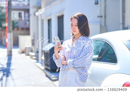 Portrait of a Japanese woman looking at her smartphone outdoors Portrait of a Japanese woman looking at her smartphone outdoors 138829409