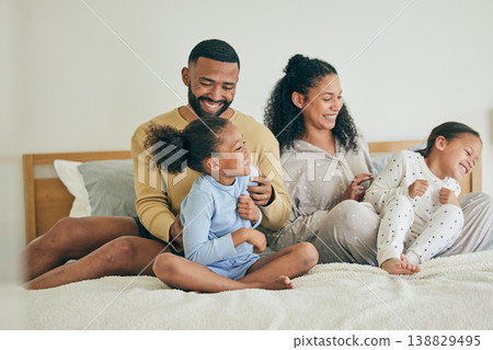 Morning, family and playful with children on bed for happiness on weekend for quality time in home. Fun, father and mother with kid together in bedroom with love or laugh and care with bonding. Morning, family and playful with children on bed for happiness on weekend for quality time in home. Fun, father and mother with kid together in bedroom with love or laugh and care with bonding. 138829495