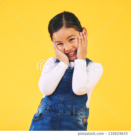 Portrait, smile and shy girl child in studio excited with news, announcement or fashion sale on yellow background. Happy, emoji and hands on face of sweet kid with promo, deal or toddler clothes info Portrait, smile and shy girl child in studio excited with news, announcement or fashion sale on yellow background. Happy, emoji and hands on face of sweet kid with promo, deal or toddler clothes info 138829635
