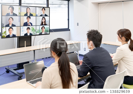 Hybrid meetings connecting remote members via large monitors. 138829639