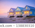 Colorful beach houses on sandy shore at sunset with cozy lights 138830310