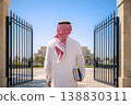 Middle Eastern man entering modern campus gate holding books from behind 138830311