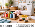 Sewing machine with colorful threads and fabric on cozy workspace table 138830340