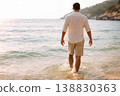Male Tourist Entering Ocean at Warm Sunny Coastline 138830363