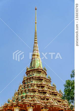 Tiny mirror pieces and gold surfaces show careful exterior work from the Rattanakosin era. The close framing reveals patient traditional craft. 138830749