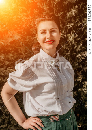 Woman smile garden smiling adult woman in embroidered blouse enjoying golden sunlight in a lush green garden setting Woman smile garden smiling adult woman in embroidered blouse enjoying golden sunlight in a lush green garden setting 138830852