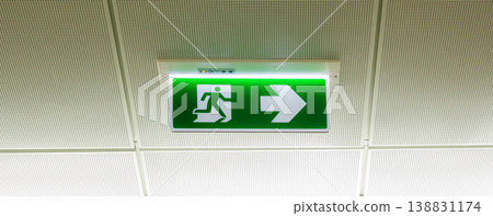 Green emergency exit sign showing the way to escape.Fire exit in the building. 138831174