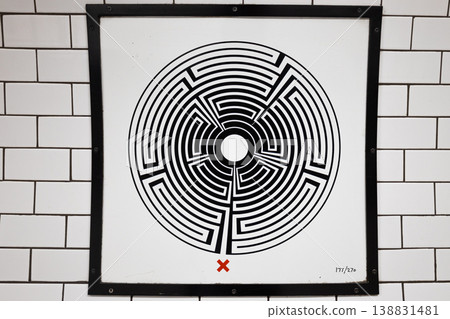 Framed black and white op art poster on white subway tile wall 138831481