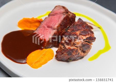 Grilled beef steak served with sauce and colorful vegetable puree on plate 138831741