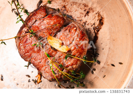 Beef roast garnished with herbs on a rustic wooden plate Beef roast garnished with herbs on a rustic wooden plate 138831743