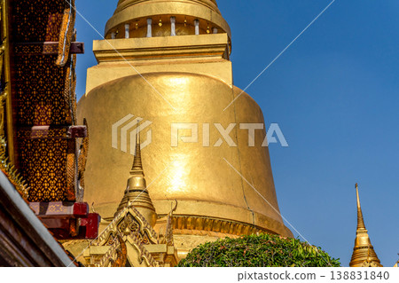 Sunlight catches mirror glass, painted surfaces, and gold edges across the temple exterior. Each close crop emphasizes texture, shine, and depth. 138831840