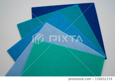 Different shades of blue felt folded vertically on top of each other. From dark blue to light blue. 138832154