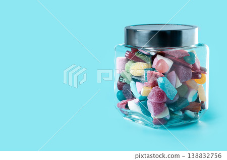 Colorful assorted gummy candies in glass jar on blue background 138832756